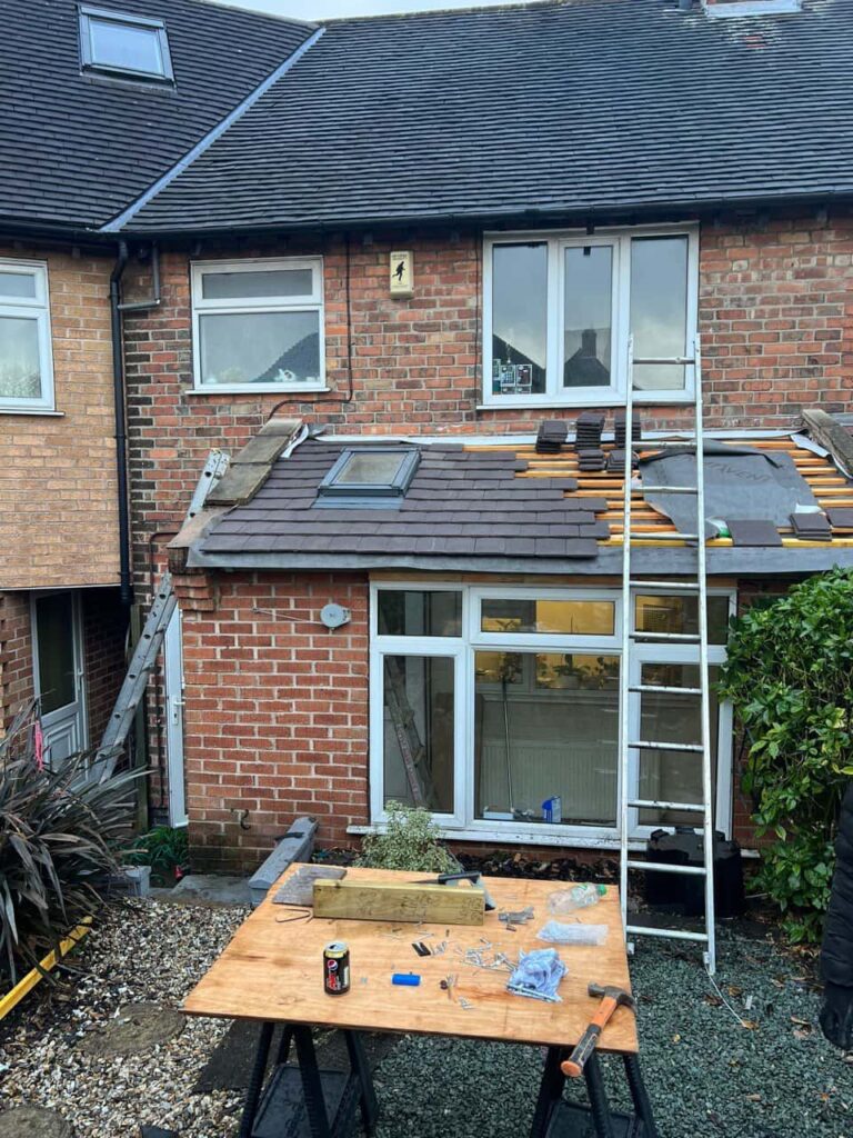 This is a photo of a roof extension that is having new roof tiles installed. This is a photo taken from the roof ridge looking down a tiled pitched roof on to a flat roof. Works carried out by Warsop Roofing Repairs