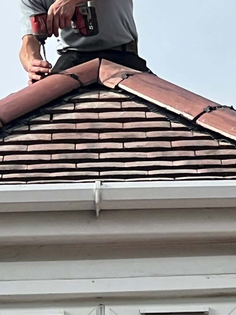 This is a photo of one of the operatives of Warsop Roofing Repairs installing new ridge tiles