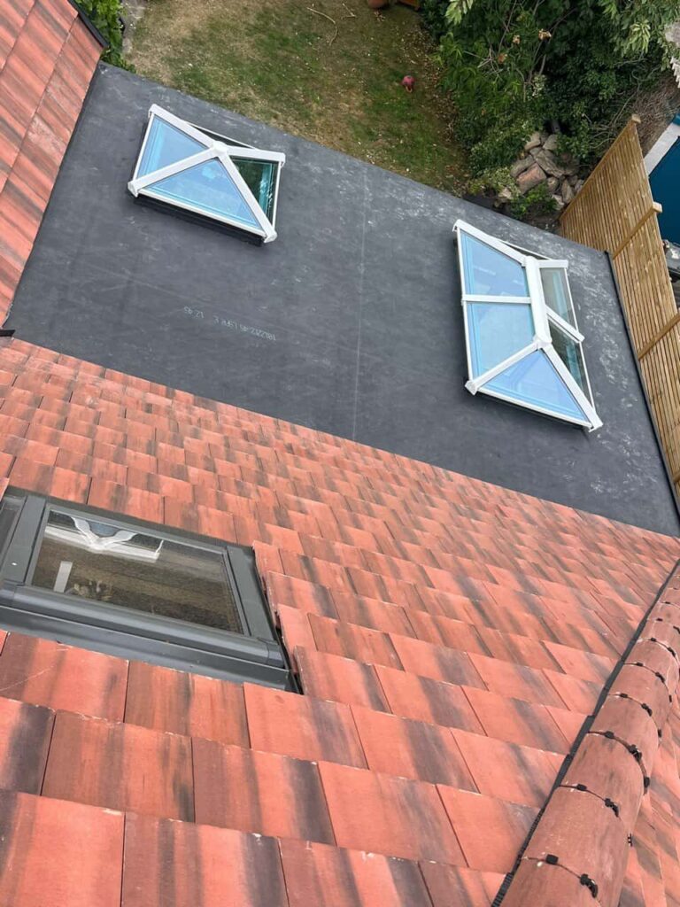 This is a photo taken from the roof ridge looking down a tiled pitched roof on to a flat roof. Works carried out by Warsop Roofing Repairs